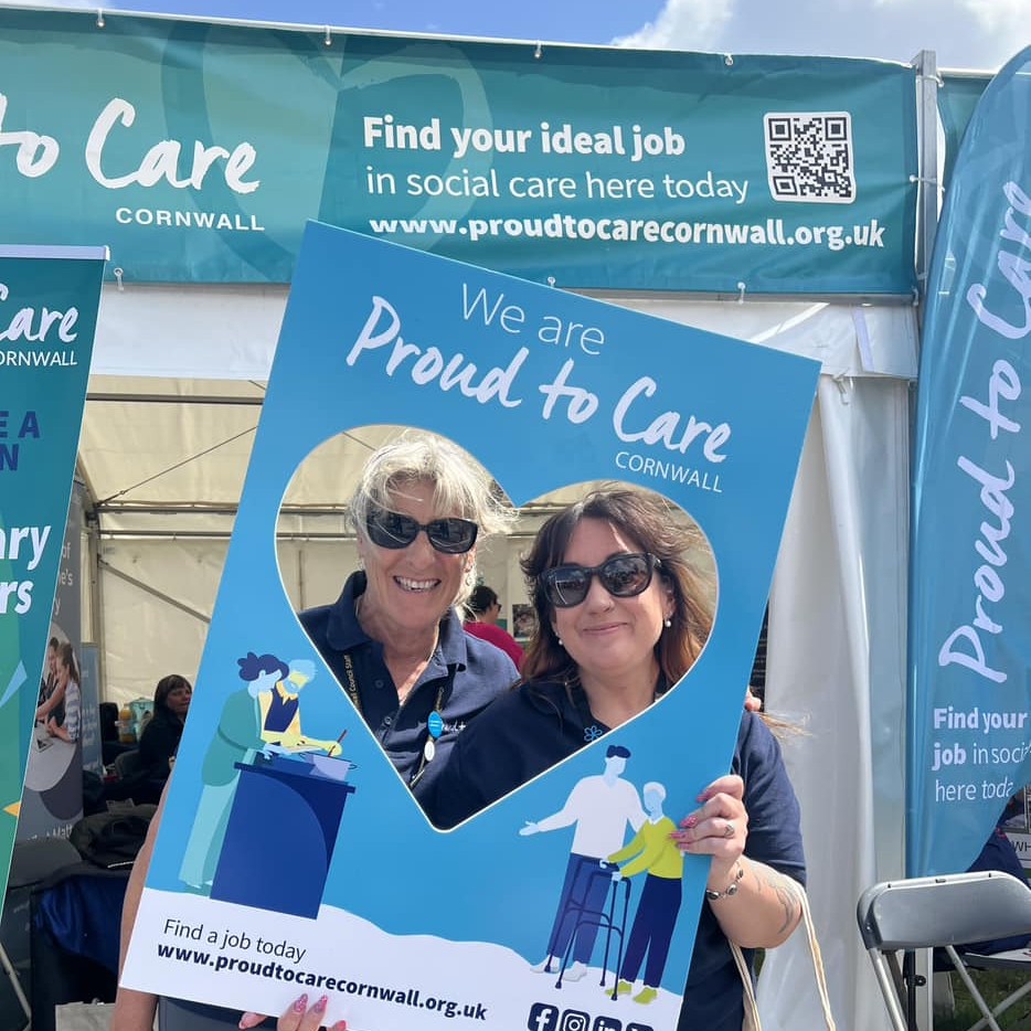 Two of the proud to care team holding a selfie board 