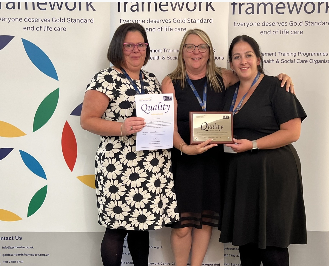 Three people stood proudly holding an award